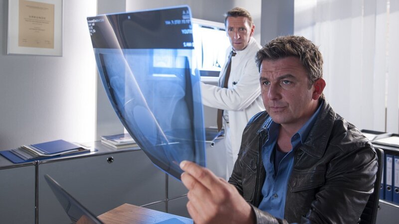 Dr. Martin Gruber (Hans Sigl, r.) und Dr. Alexander Kahnweiler (Mark Keller, l.) entdecken einen Nagel im Kopf ihres Patienten Hannes Finke. – Bild: ZDF und Stefanie Leo