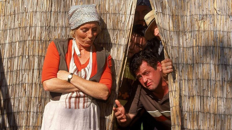 Uschi (Antje Lewald) hört Benno (Willi Thomczyk) und die anderen Männer hinter dem Zaun tuscheln und pullern. Da möchte sie doch mal wissen, warum die Herren der Schöpfung nicht zur Toilette gehen … – Bild: RTL Deutschland