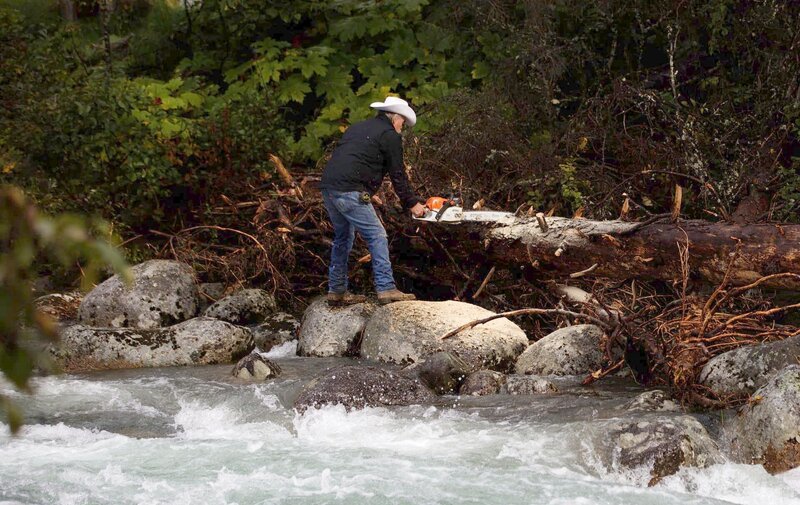 Marty Raney chopping up a log on the side of the river. – Bild: Warner Bros. Discovery, Inc. or its subsidiaries and affiliates