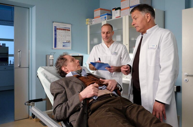 Thomas Bruhnke (Oliver Törner, li.) wird mit Schmerzen in die Sachsenklinik eingeliefert. Dr. Roland Heilmann (Thomas Rühmann, re.) hat den Verdacht auf eine Blinddarmentzündung und nimmt den Patienten auf. – Bild: MDR/​saxonia media/​Kiss