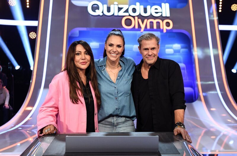 Quizmasterin Esther Sedlaczek (M.) mit den Kandidat:innen des Teams „Hauptrolle“: Simone Thomalla (l.) und Sven Martinek (r.). – Bild: ARD/​Uwe Ernst