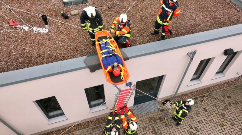 Übungseinsatz für die Erwachsenen. Die Kameraden aus Donndorf trainieren das Bergen verletzter Personen vom Dach. – Bild: MDR/​Norbert Roßbach