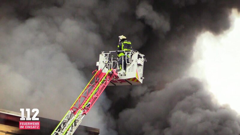 A column of black smoke hangs over the city while emergency services tries to bring the inferno under their control. – Bild: DMAX