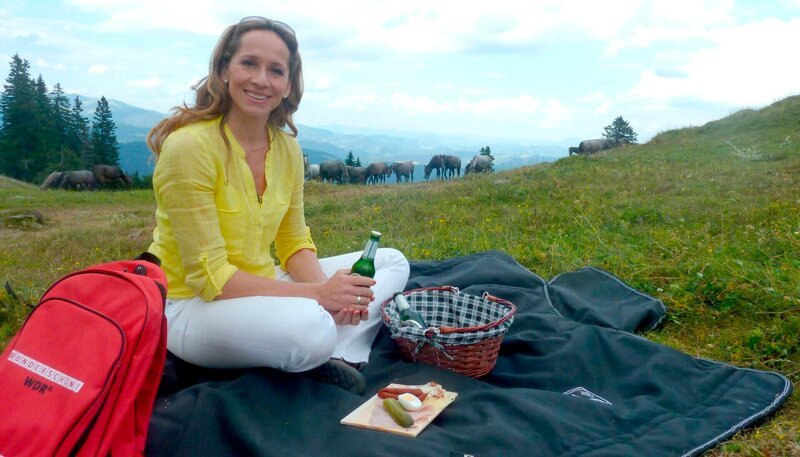 WDR Fernsehen WUNDERSCHÖN!, „Südliche Steiermark“, Unterwegs mit Tamina Kallert durch Österreichs Genussregion am Sonntag um 20:15 Uhr. Moderatorin Tamina Kallert beim Picknick auf der Stubalpe dort, wo die jungen Lipizzanerhengste des Staatsgestüts Piber im Sommer grasen. – Bild: BR/​WDR/​C. Voß-Schuler