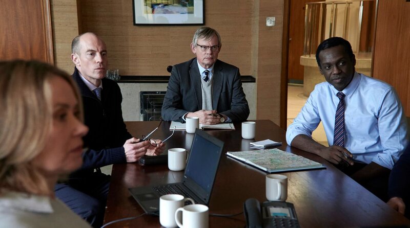 v.l.n.r.: DS Kathy Rook (Beth Goddard), DI Nathan Eason (Matthew Gravelle), DCI Colin Sutton (Martin Clunes) und DS Neville Hylton (Sule Rimi) im Konferenzraum beim Sichten der Überwachungsaufnahmen rund um den Geldautomaten. – Bild: WDR/​Buffalo Pictures & A3MI