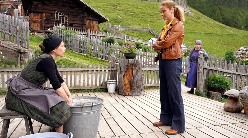 Marianne Egger (Meike Droste, li.) wird von „Capo“ Sonja Schwarz (Chiara Schoras, Mitte) befragt, Helena Egger (Annalena Hochgruber, re.) beobachtet sie. – Bild: ARD Degeto/​Hans Joachim Pfeiffer