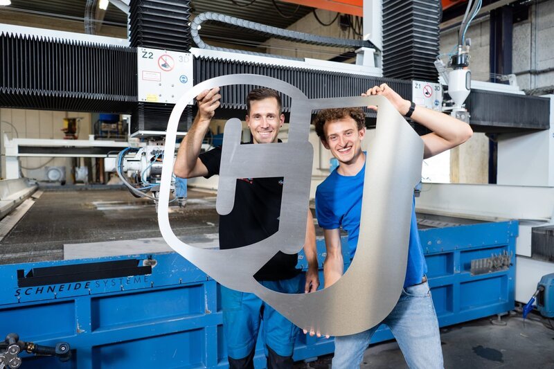 In Salzburg trifft Julian den Wasserstrahlschneide-Experten Robert (links). Gemeinsam mit ihm checkt Julian, was Wasser alles schneiden kann. – Bild: BR/​megaherz gmbh/​Hans-Florian Hopfner