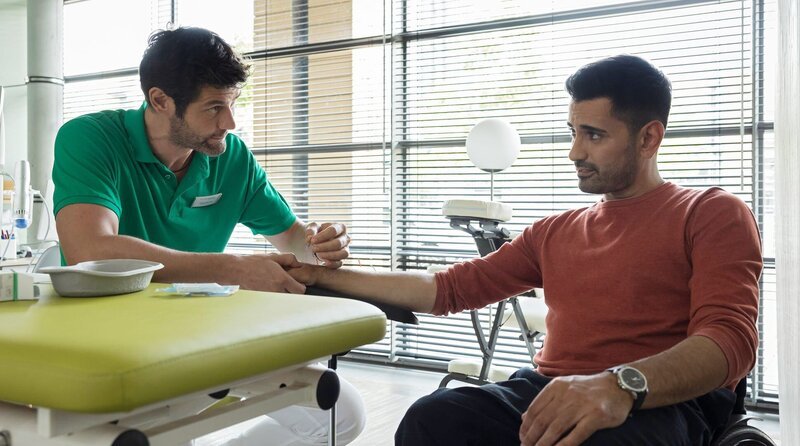 Dr. Ilay Demir versucht eine neue Therapie bei Darren Macneil. Ilay will nach seiner Verletzung schnell wieder arbeiten. – Bild: MDR/​Rudolf Wernicke