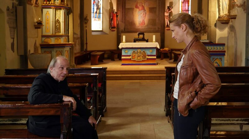 Etwas stimmt in der Gemeinde nicht! Sonja (Chiara Schoras) vernimmt den langjährigen Pastor Magnus Holzer (Nikolaus Paryla). – Bild: ARD Degeto/​BR/​Hans-Joachim Pfeiffer