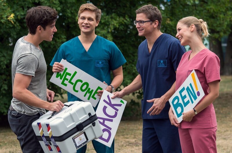 Ben (Philipp Danne, l.) ist endlich wieder zurück. Seine Kollegen Mikko (Luan Gummich, 2.v.l.), Elias (Stefan Ruppe, 2.v.r.) und Julia (Mirka Pigulla, r.) begrüßen ihn freudig. – Bild: ARD/​BR/​Jens Ulrich Koch