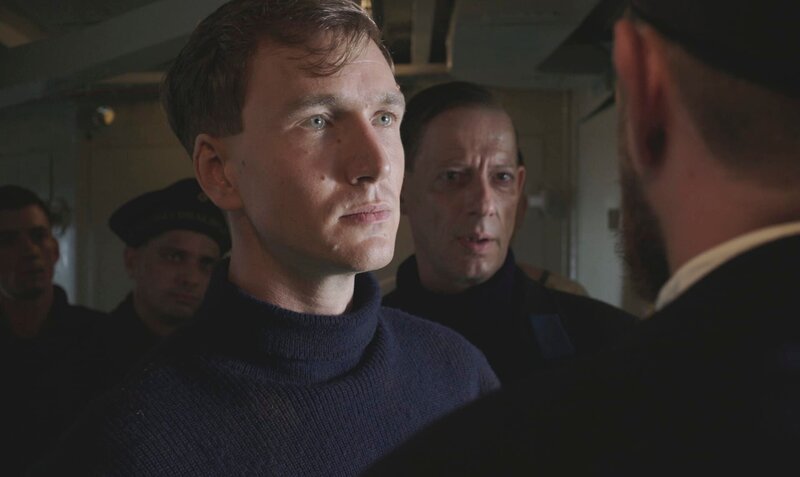 Hans Beimler (Jan Krauter) ist Obermaat bei der kaiserlichen Hochseeflotte in Cuxhaven. im Hindergrund Luc Feit als Heester. – Bild: SWR/​LOOKSfilm/​J. Rehberg