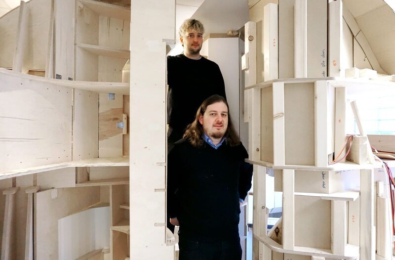 Nachtzugabteil-Designer Hendrik Lucka (hinten) und Mathematiker Anton Dubrau im Prototyp (aus Holz) ihrer konstruierten Nachtzugkabine. – Bild: MDR/​Ella Cieslinski