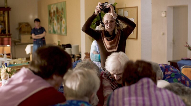 Johanna Schreier (Mareike Beykirch) fotografiert eine Gruppe Senioren. – Bild: WDR/JORONI Film/CZAR Film Johanna Schreier (Mareike Beykirch) fotografiert eine Gruppe Senioren. – Bild: WDR/JORONI Film/CZAR Film