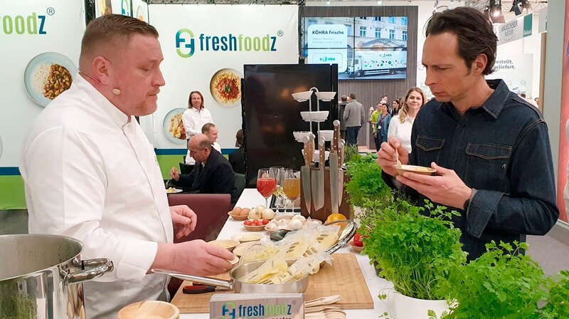 Jo Hiller spricht mit Ausstellern auf einer Gastro-Messe über das riesige Angebot an Convenience-Produkten. – Bild: NDR/​Anneke Müller