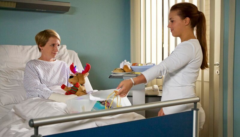 Schwester Julia (Sarah Tkotsch, re.) bringt Manuela Wüllner (Fanny Staffa, li.) ihr Essen, welches ab jetzt eine ärztliche Anordnung ist. Bei Manuela hat sich aufgrund ihrer schlechten Lebensführung eine Osteoporose entwickelt. Manuela nimmt in ihrem Leben alles schwerer als es ohnehin schon ist. Sie muss von den Menschen in ihrem Umfeld immer wieder motiviert werden, allen voran ihre Kollegin und Freundin Nadine. Doch die hat gerade richtig Mist gebaut. – Bild: MDR/​Sasxonia /​Wernicke