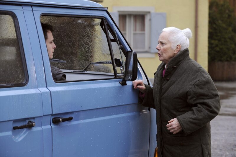 Theres braucht ein größeres Auto, um alle Senioren in ihrem Shuttle unterzubringen. Von links: Florian (Tommy Schwimmer) und Theresa Brunner (Ursula Erber). – Bild: BR/​Marco Orlando Pichler