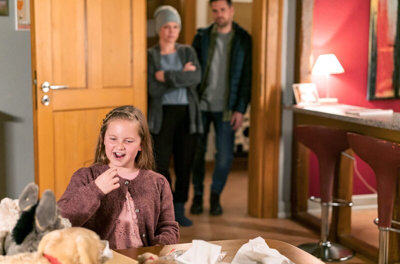 Carlotta (Mila Breiter) möchte sich unbedingt für ihre Mutter testen lassen. Sie versteht nicht, warum Kinder nicht zugelassen sind. im Hintergrund: Eva (Lucie Muhr), Andreas (Ralph Gassmann) – Bild: SWR/​Christian Koch