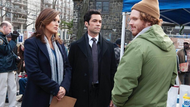 Detective Olivia Benson (Mariska Hargitay) und Detective Nick Amaro (Danny Pino, M.) befragen den Occupy-Demonstranten Kenny (Jacob Wallach): Der Chef eines Militärlieferanten wurde unter Drogen gesetzt, vergewaltigt und anschließend im Park ausgesetzt. – Bild: TVNOW /​Universal