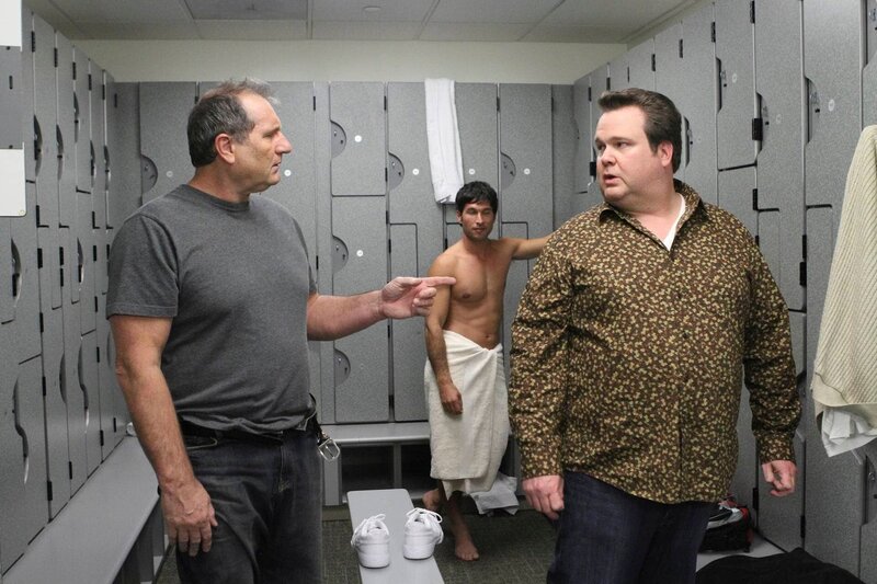 Jay (Ed O’Neill) spielt wie Cameron (Eric Stonestreet) gerne Squash, doch ihm graut es davor, mit dem homosexuellen Cameron gemeinsam in der Männerumkleide zu sein. – Bild: Universal TV