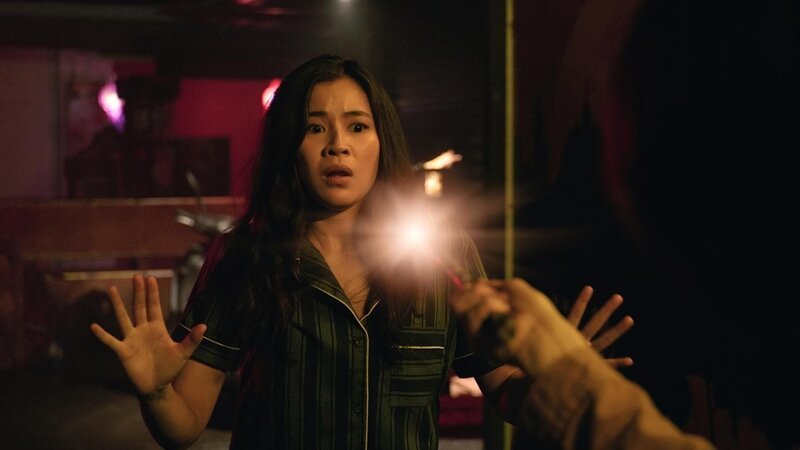 Kyra (Kimie Tsukakoshi) wurde ohne ihr Zutun in ein Lagerhaus in Thailand teleportiert. Dort wird sie von einer Elfe entdeckt, die sie verdächtigt, etwas stehlen zu wollen. – Bild: ZDF/​2020 Jonathan M. Shiff Productions
