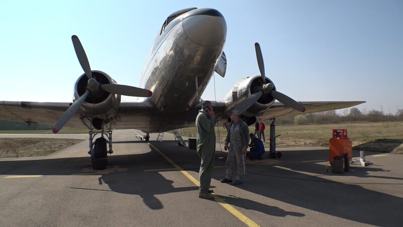 Michael Manousakis (l.) neben der DC-3. – Bild: Warner Bros. Discovery