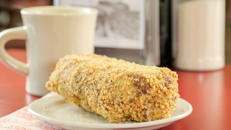 Die Bewohner von Buffalo lieben den „Peanut Stick“, einen großen, länglichen Donut mit einer leichten Glasur und fein gehackten Erdnüssen, bei „Paula’s Donuts“ in Buffalo, New York. – Bild: ORF/​Warner/​The Travel Channel