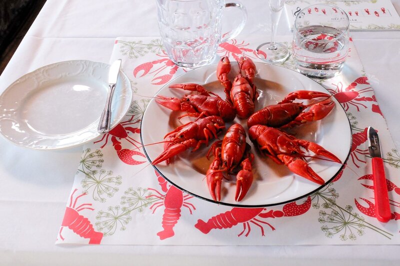 Die „Rapu“ – kleinen Süßwasserkrebse – werden oft mit festlichen Servietten und Tischdecken mit Flusskrebsmotiven serviert. – Bild: ORF/​Warner/​The Travel Channel