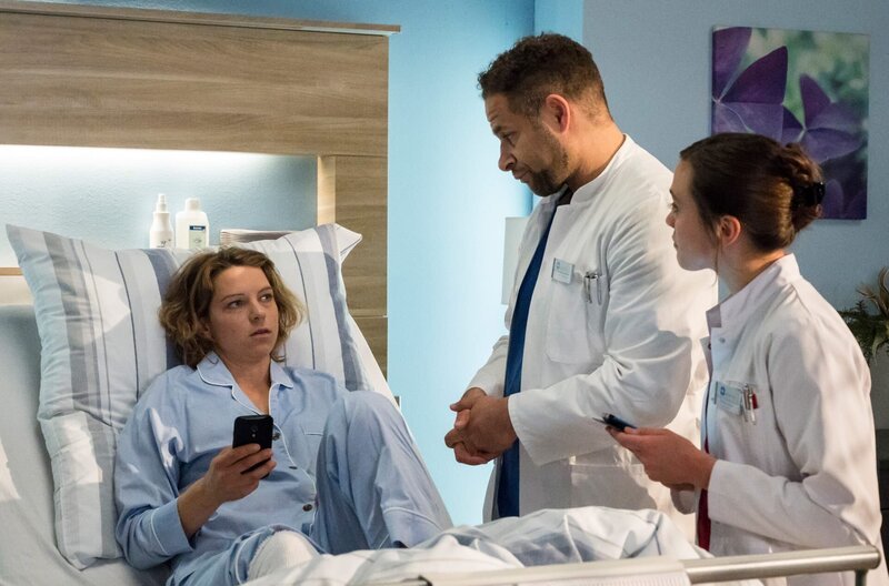 Ines Herwig (Anjorka Strechel, l.) geht es noch nicht besser. Dr. Matteo Moreau (Mike Adler, 2.v.r.) und Rebecca Krieger (Milena Straube, r.) müssen weiter nach der Ursache forschen. – Bild: ARD/​Jens Ulrich Koch