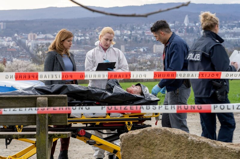 Dr. Judith Engel (Astrid Posner, 2.v.l.) gibt Hauptkommissarin Kerstin Klar (Fiona Coors, l.) und Oberkommissar Max Fischer (Max Hemmersdorfer, 2.v.r.) erste Informationen zu einem neuen Todesfall. – Bild: Andrea Enderlein /​ ZDF Enterprises GmbH /​ Die Verwendung ist nur bei redaktioneller Berichterstattung im Rahmen einer Programmankündigung ab 2 Monate vor der ersten Auss /​ © ZDF/​Andrea Enderlein/​Peter Porst