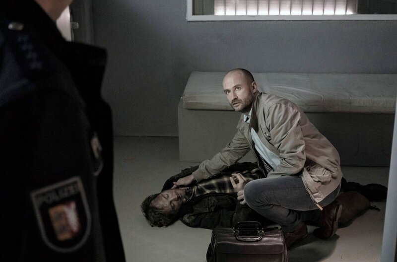 Der Amtsarzt (Georges Pauly, r.) kann nur noch den Tod von Patrick Hilgersen (Tom Radisch, liegend) feststellen. – Bild: ARD/​Georges Pauly