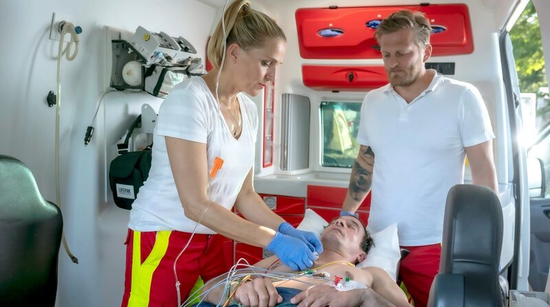Nora (Tanja Wedhorn) und Lars (Bo Hansenl, re.) versorgen den Patienten Florian Becker (Sönke Möhring). – Bild: ARD Degeto/​Boris Laewen