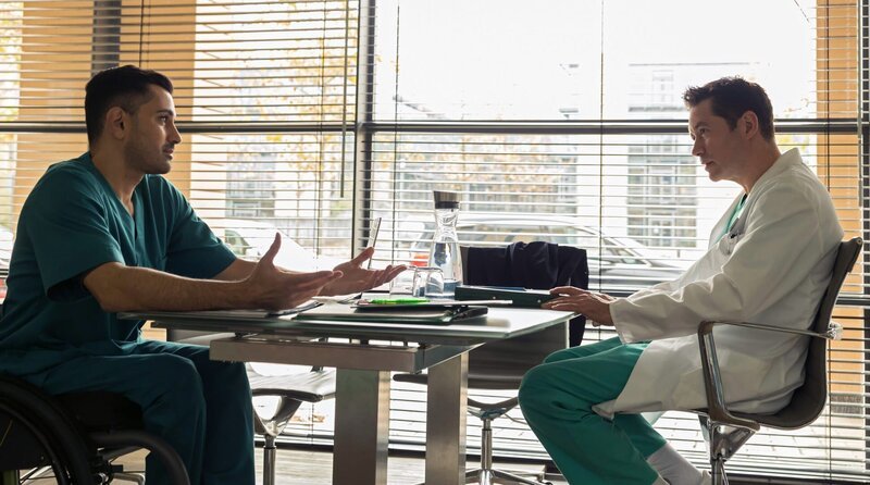 Dr. Ilay Demir (Tan Caglar, li.) und Dr. Philipp Brentano (Thomas Koch, re.) diskutieren darüber, ob es vertretbar ist, einem Patienten das Bein abzunehmen, wenn keine ausreichende medizinische Indikation vorliegt. – Bild: MDR/​Rudolf Wernicke