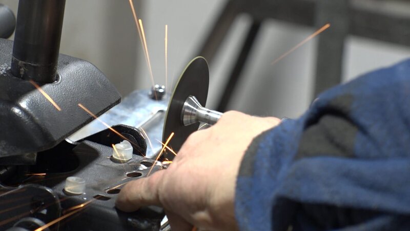 Der Mechaniker schneidet das Metallteil. – Bild: Warner Bros. Discovery