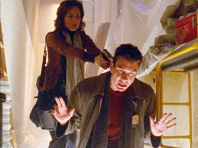 Woody (Jerry O’Connell) wird von der Mordverdächtigen, Pamela Bragman (Lola Glaudini), bei einer Verfolgungsjagd von hinten überrascht. Wird sie ihn erschießen? – Bild: RTL /​ NBC Universal