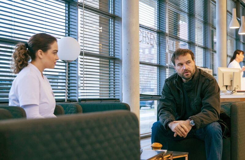 Christian Mendes (Simon Eckert) erzählt Pflegerin Jasmin Hatem (Leslie-Vanessa Lill), wie es über die Pflege und die Sorge ihrer gemeinsamen Tochter zu der Trennung von seiner Frau kam. Es war einfach keine Zeit und kein gegenseitiges Verständnis mehr da. – Bild: MDR/​Sebastian Becker