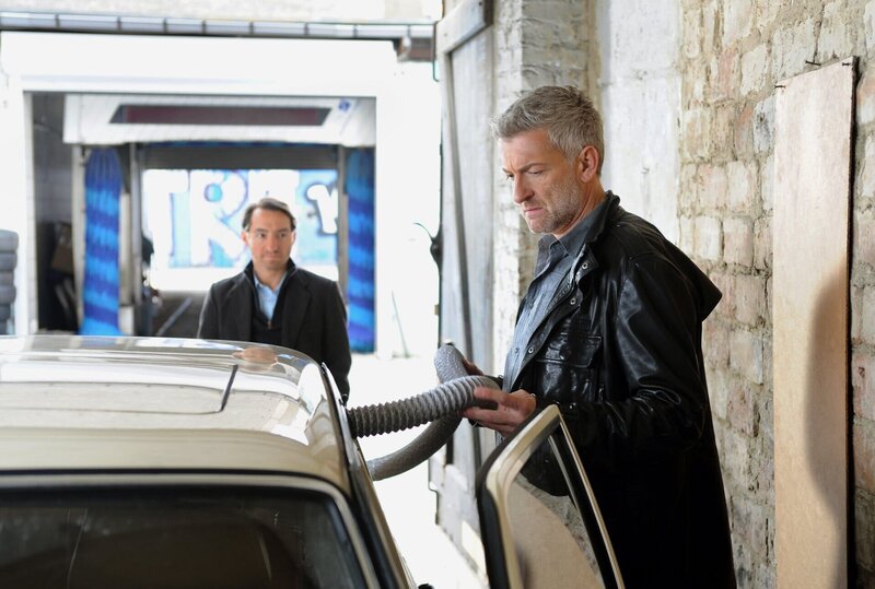 Ritter (Dominic Raacke) kann den Tod seines Onkels nicht fassen (im Hintergrund: B. Aljinovic). – Bild: rbb/​Hans-Joachim Pfeiffer