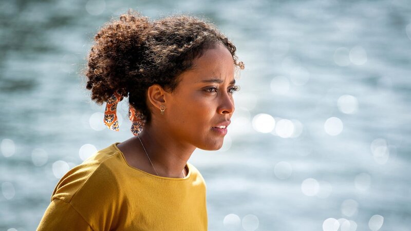 Elli (Pia Amofa-Antwi) ist hin- und hergerissen: Sie hat sich unter falschem Namen beim „Feind“ eingeschlichen, um die Wahrheit herauszufinden, entwickelt aber Gefühle für ihren neuen Arbeitgeber. – Bild: ZDF und Ralf Wilschewski