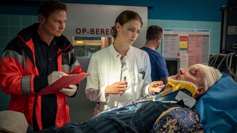 Dr. Haase (Fabian Harloff, l.) übergibt Dr. Eva Grünberg (Laura Berlin, M.) den Patienten Mark Peters (Benjamin Utzerath, r.). – Bild: ZDF und Boris Laewen (bola)