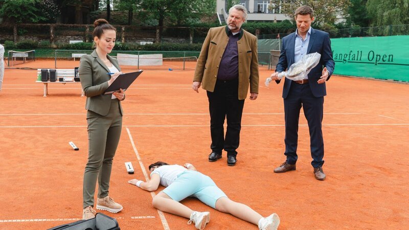 Pathologin Atay (Sevda Polat, l.) schildert den Kommissaren Stadler (Dieter Fischer, M.) und Hansen (Igor Jefti?, r.), dass das Opfer Brigitta Roth mit einem Tennisschläger von hinten erschlagen wurde. – Bild: ZDF und Linda Gschwentner