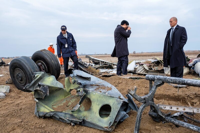 Ein Ermittler (gespielt von James Chung) fotografiert die Überreste von China-Airlines-Flug 140, während der leitende Ermittler (gespielt von Von Flores) zuschaut. AAIC-Ermittler und Bergungsarbeiter (gespielt von Schauspielern im Hintergrund) untersuchen die Szene. – Bild: PLURIMEDIA (Cineflix /​ Darren Goldstein)