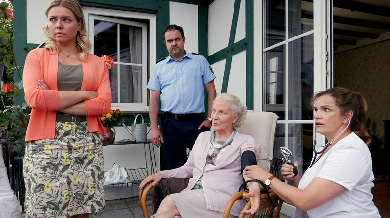Frau Böhl (Marie Anne Fliegel) mit ihrem Sohn Volker (Tom Keune), Pflegerin Danuta (Karolina Lodyga) und der Versorgungsassistentin Vera (Rebecca Immanuel) – Bild: ARD Degeto/​Hans-Joachim Pfeiffer