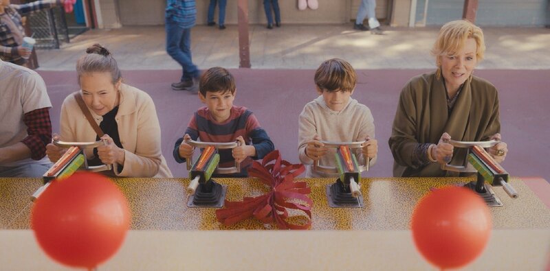 Deborah (Jean Smart, r.) lädt ihre alte Comedy-Kollegin Susan (Harriet Sansom Harris, l.) und deren zwei Enkel Mason (Henry Samiri, 2.v.l.) und Keller (Elaye Handal, 2.v.r.) zum Jahrmarkt ein. Doch auch beim Schießstand kann Deborah nicht anders, als sich erneut mit Susan zu messen – ein impulsiver Moment, der alte Wunden aufreißt. – Bild: ZDF und Karen Ballard