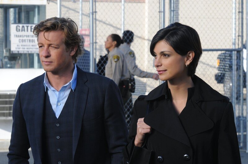 Patrick Jane (Simon Baker, l.) erhält einen Anruf von der ehemaligen Partnervermittlerin Erica Flynn (Morena Baccarin, r.), die im Gefängnis sitzt, nachdem er sie im Jahr zuvor des Mordes an ihrem Mann überführt hatte. Erica behauptet, sie könne ihm in seinem neuen Fall helfen, allerdings, werde sie dem CBI nur helfen, wenn Patrick einen Hafturlaub für sie erwirken könne … – Bild: Warner Bros. Television Lizenzbild frei
