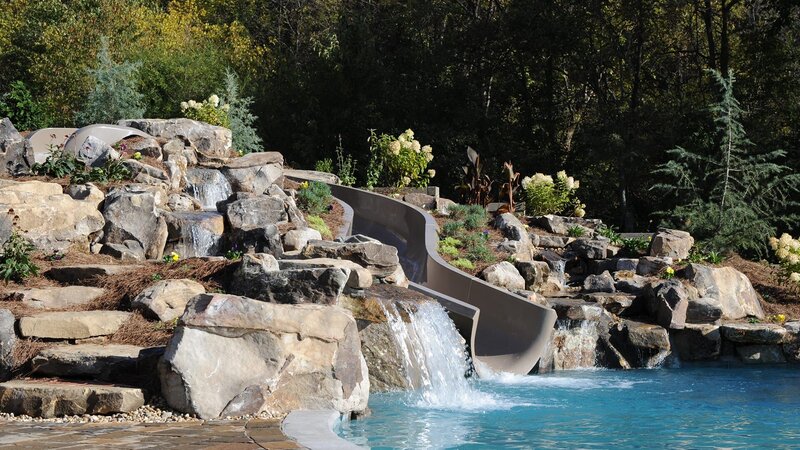 Peek Pools and Spas added a slide and rock work to the pool, as seen on Pool Kings. – Bild: Warner Bros. Discovery