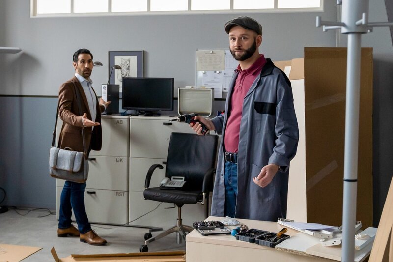 Controller Daniel Donato (Paul Brusa, l.) kann nicht fassen, dass Hausmeister Hannes Winkler (Steffen Wolf, r.) noch immer nicht mit dem Aufbau der neuen Schreibtische fertig ist. – Bild: ORF/​ZDF/​Linda Gschwentner