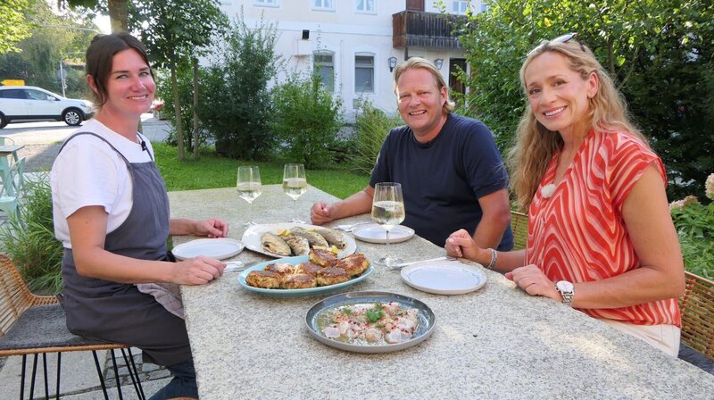 Regionale Spezialitäten im Fokus: Tamina Kallert (r) und Björn Freitag bei Renke und Kaspressknödel mit Köchin und lokaler Expertin Vroni Lutz (l) in ihrem Restaurant. – Bild: WDR/​2bild GmbH/​Franziska Reinhardt