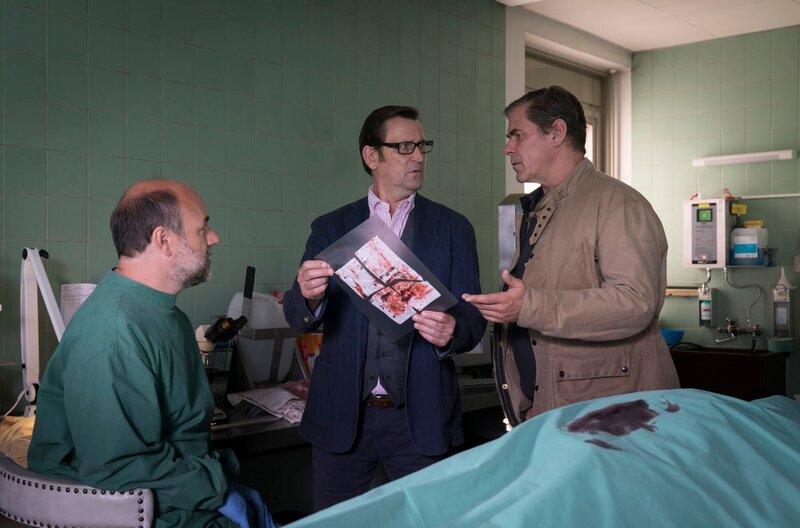 Dr. Strahl (Christoph Tomanek, l.) findet bei der toten Seniorin einen Zettel. Der Inhalt des Schreibens veranlasst Lars (Ingo Naujoks, M.) und Finn (Sven Martinek, r.) den Tatort noch einmal genauer zu untersuchen. – Bild: ARD/​Sandra Hoever