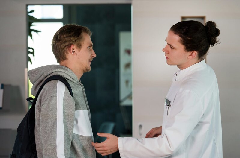 In Jonas Kunzes (Joshua Seelenbinder, l.) Ohr steckt ein Wattestäbchen. Kann Tom Zondek (Tilman Pörzgen, r.) den jungen Mann von seinem Missgeschick befreien? – Bild: ARD/​Jens Ulrich Koch