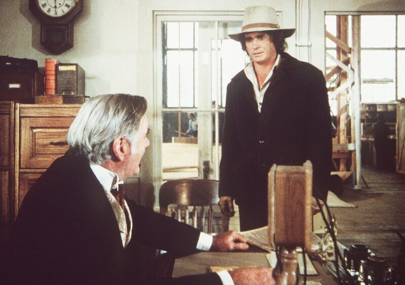 Charles (Michael Landon, r.) stellt den Fabrikanten Addison Fisk (Paul Larson, l.) zur Rede, da dieser einen von ihm entworfenen Tisch in Massenproduktion herstellt. – Bild: Worldvision