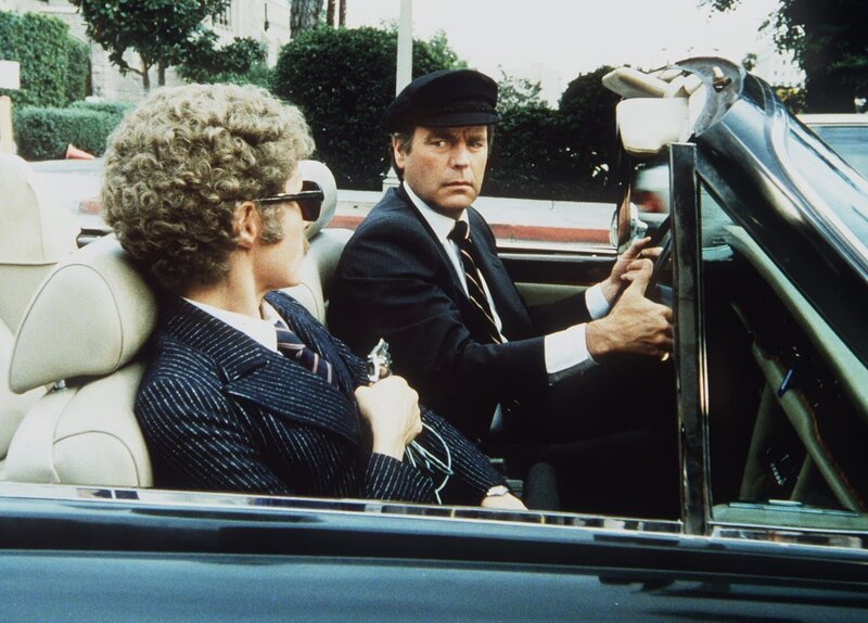Eve (Julie Newmar, l.) hält Jonathan (Robert Wagner, r.) für einen Chauffeur und lässt sich von ihm zu seinem Haus fahren. – Bild: Columbia Pictures